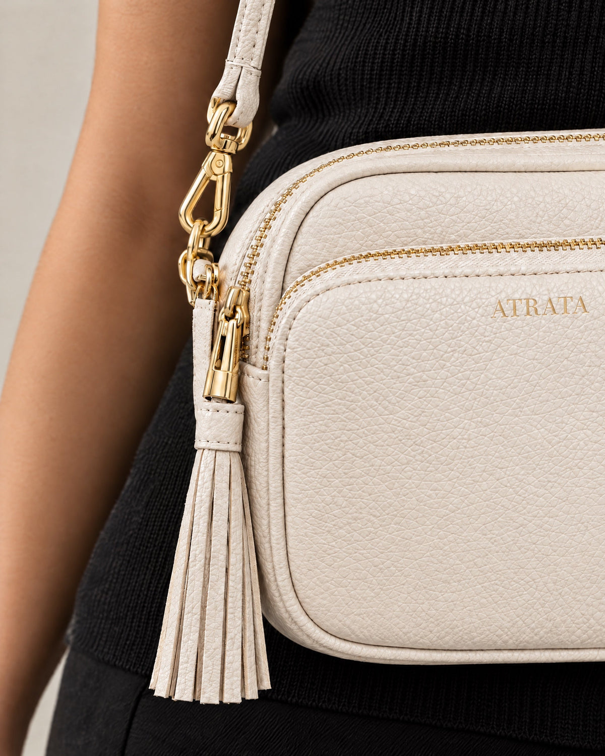 The Muse Crossbody, close-up of the gold zip, tassel and pebbled leather