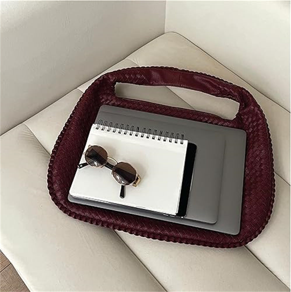The Ember Bag, in wine red, flat-lay with laptop and sunglasses