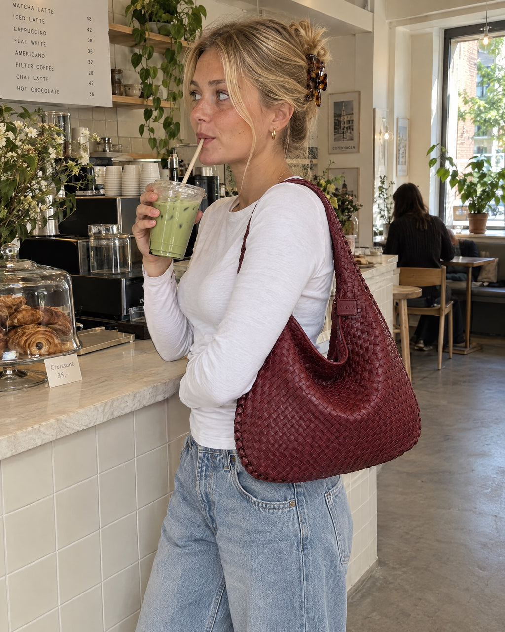 The Ember Bag, worn on the shoulder in a café