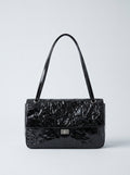 The Statement Flap Bag, front view in black